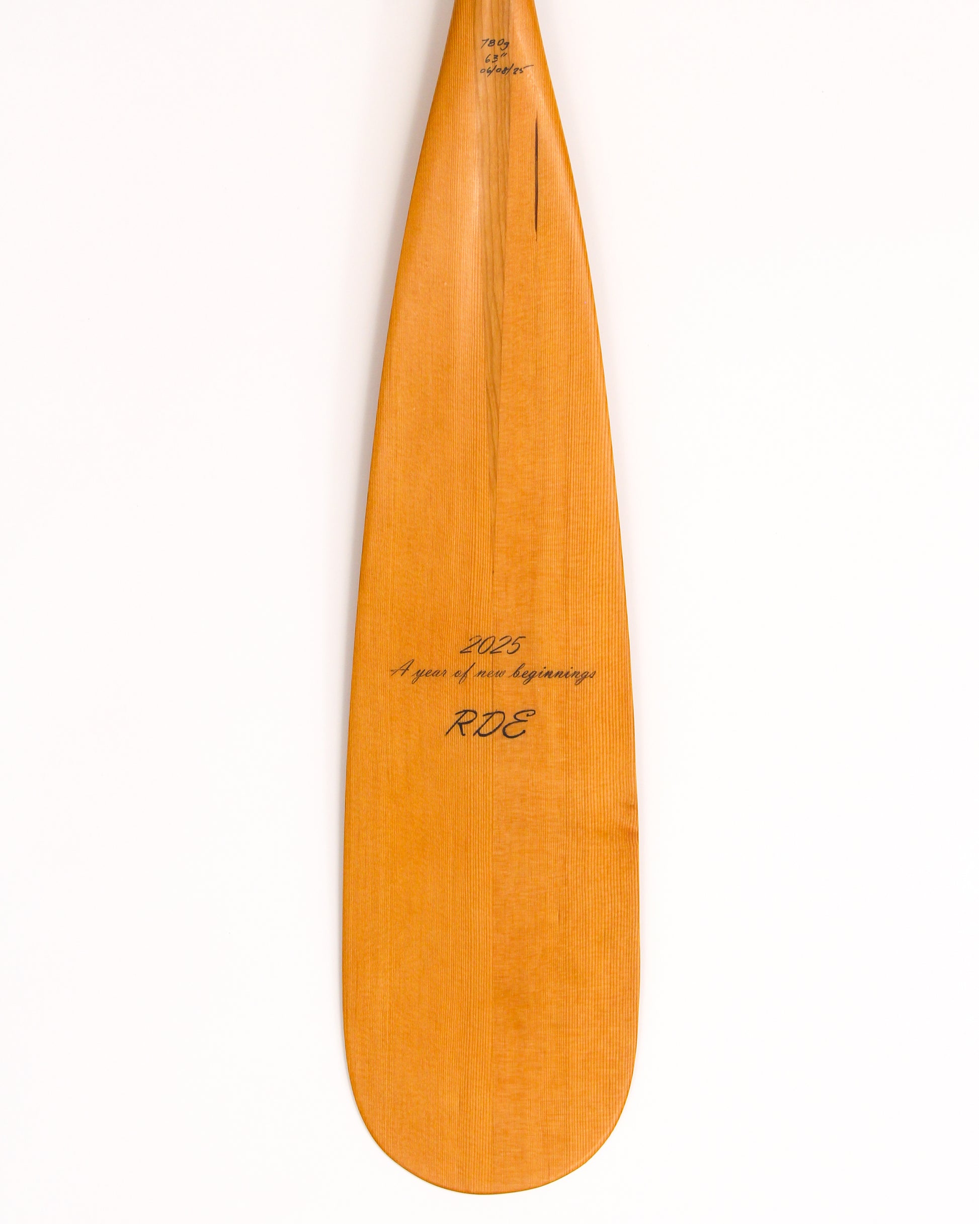 a beavertail canoe paddle that has a light colored blade and a light cherry inlay for the grip and shaft. made with BC fir and walnut and cherry hardwood. the picture shows a detail of the grip and blade