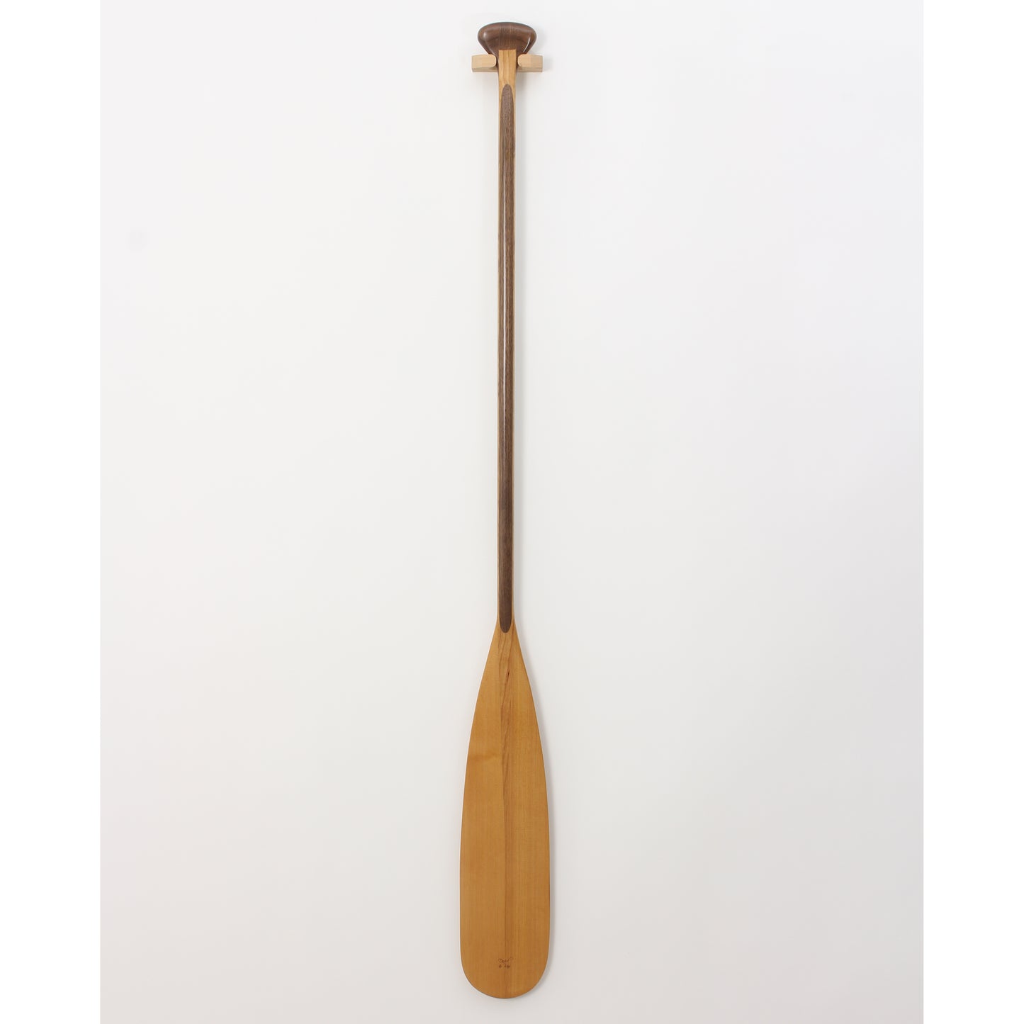 A classic beavertail canoe paddle with a laminated shaft and a pear-shaped grip, featuring a light-colored blade and a darker shaft, displayed against a white background.