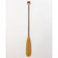 A classic beavertail canoe paddle with a laminated shaft and a pear-shaped grip, featuring a light-colored blade and a darker shaft, displayed against a white background.